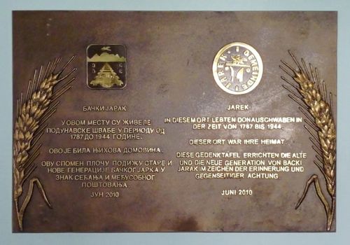 Bild 2: Die Jareker Gedenktafel im Eingangsbereich des Gemeindehauses in Bački Jarak Unter den Gemeindewappen von Bački Jarak (links) und Jarek (rechts steht jeweils der selbe Text in Serbisch und Deutsch.